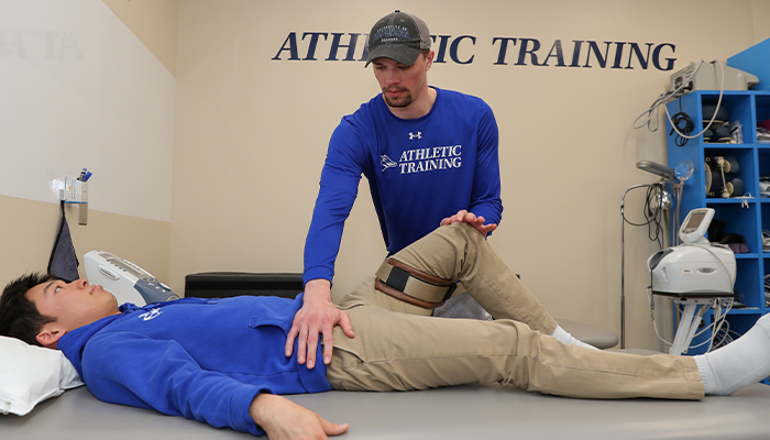 a student works with a patient at an athletic training clinic