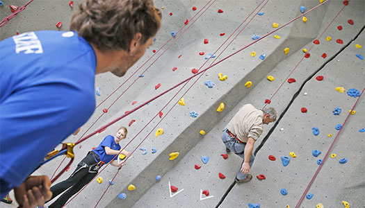 太阳城娱乐官网 student climbing the rock wall at the wellness center