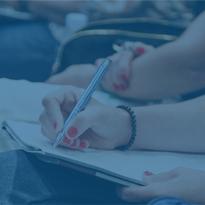 close up of hands writing in a notebook