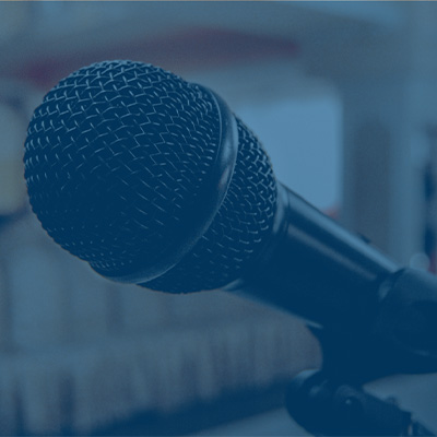 a speaker stands at a podium with his laptop