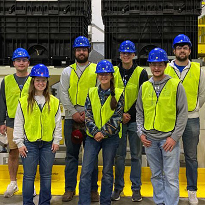students pose in safety vests at a factory tour event