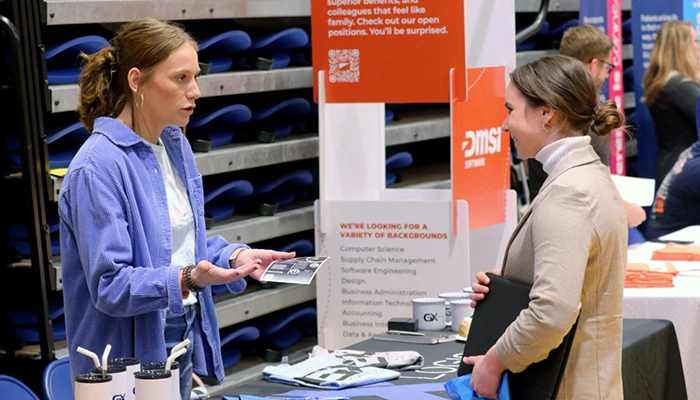 a student speaks with booth attendant at a career and internship fair