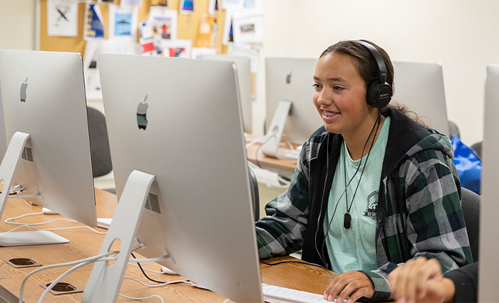 a student smiles while using a computer