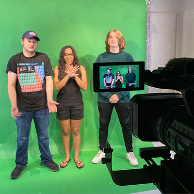 students stand in front of green screen