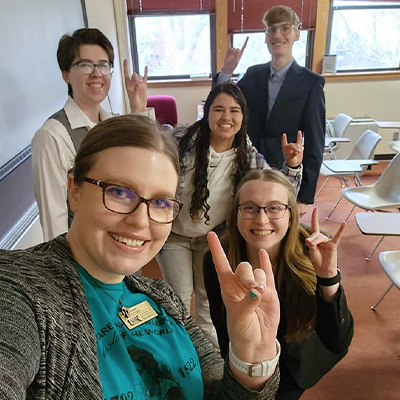 students pose for a selfie with a faculty member