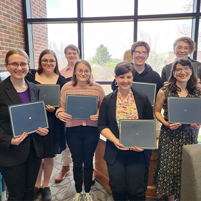english students pose for a photo holding certificates