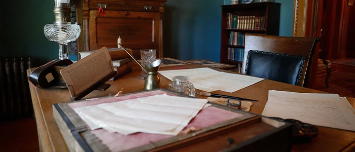 a photo of an antique desk with papers on it