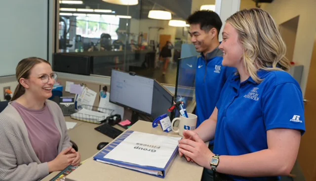 student and staff talking at welcome desk