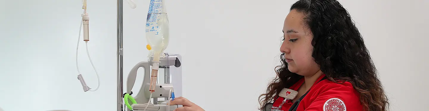 护理 student practicing with a health doll