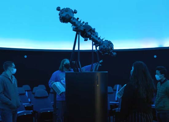 students listen to an instructor in a classroom
