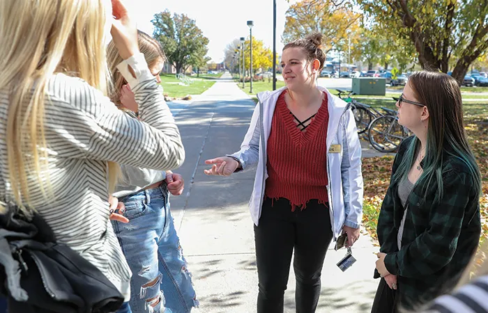 a tour guide talks with a group outside
