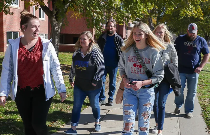 a tour guide and group walk across campus
