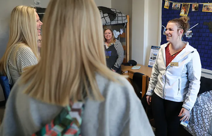 a tour guide shows off a unk dorm room
