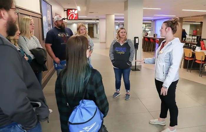 a tour guide speaks to a group in the student union food court