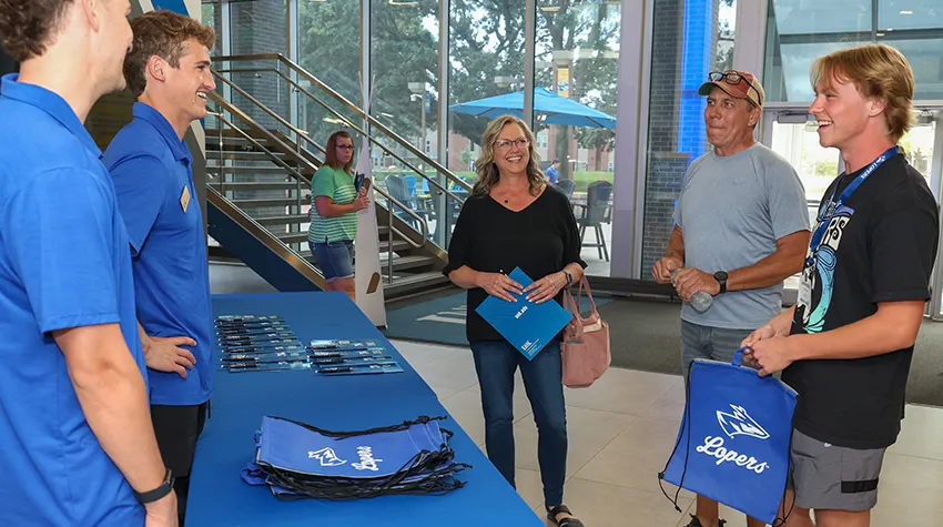 students talk with workers at a booth in the student union