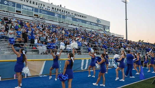 the unk cheer team performs for a full crowd