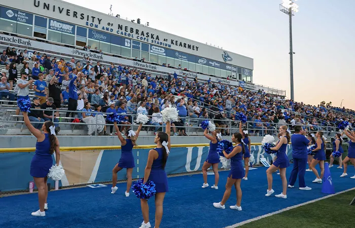 the unk cheer team perform in front of a full grandstand