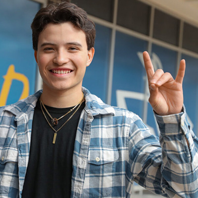 a student stands outside and thows the lopes