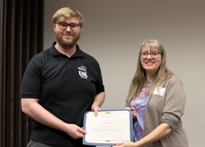 Woman presenting man with award.