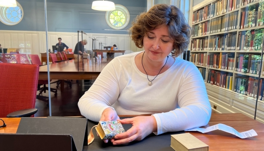 Christy looking at miniature book at Harvard.