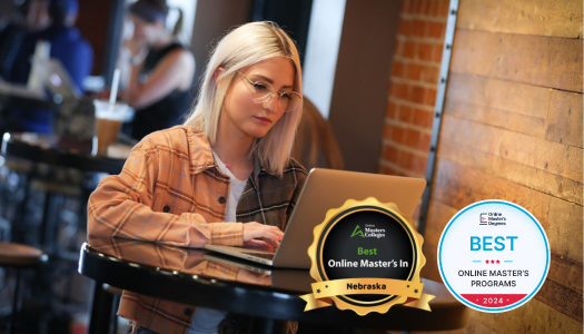 Woman at a coffee shop table with her laptop open.
