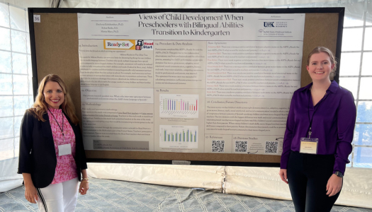 Two women standing in front of a research poster.
