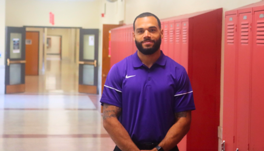Man standing in front of school lockers.
