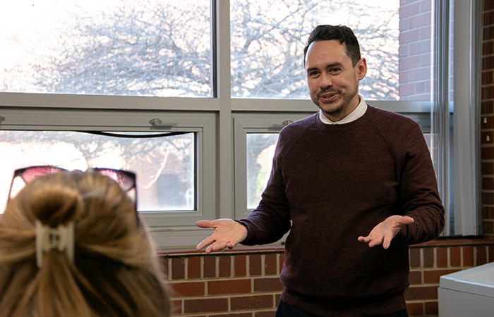 Spanish teacher gesturing at his class with his palms up during a Spanish lesson.