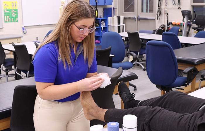 Athletic training student wrapping an ankle.