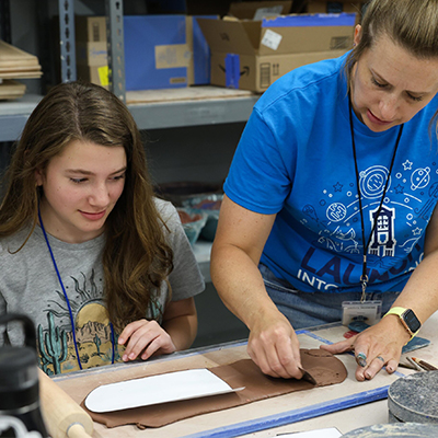 a student and instructor work on a project in class