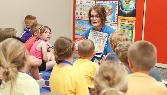 an instructor reads to a classroom full of students