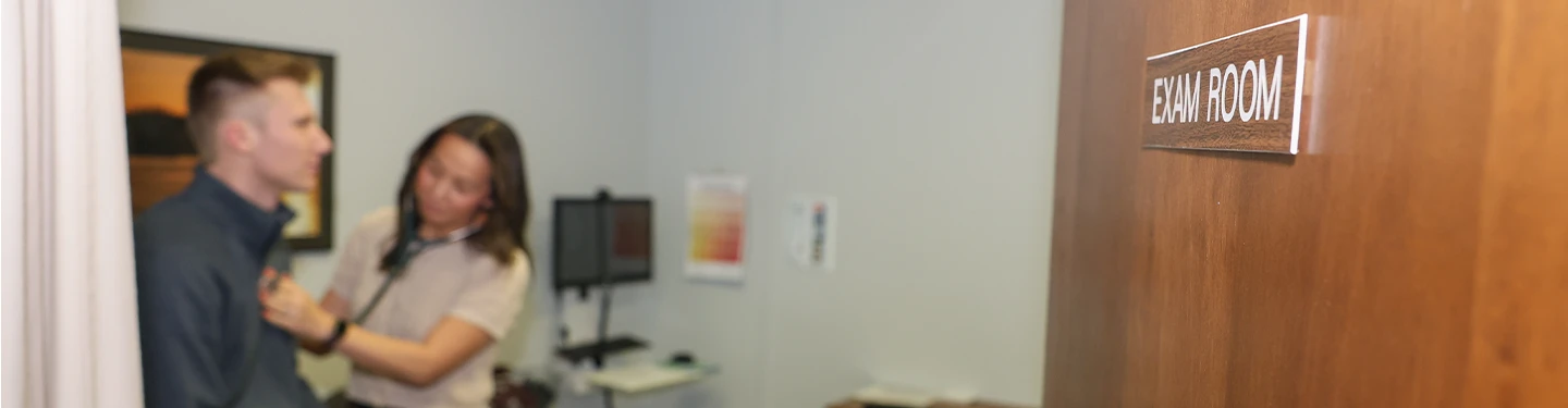 exam room door, in the background we can make out a student receiving an exam