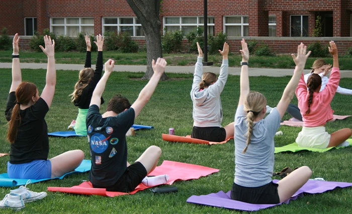 students do yoga on campus greens
