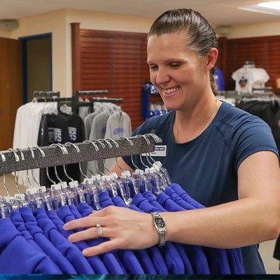 a woman browses hoodies at the loper spirit shop