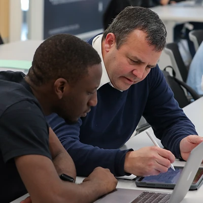 a faculty member works with a student in class