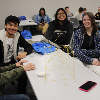 students gather around a table during a class