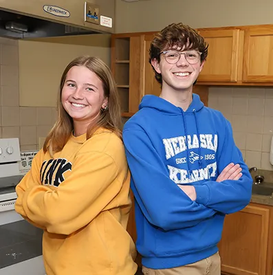 two students stand back to back