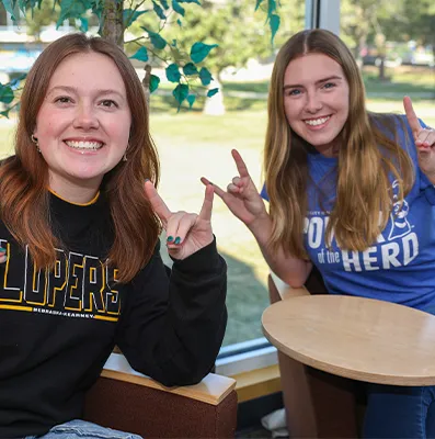 two students sit together and pose for a photo
