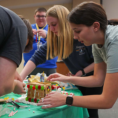 students work on a gingerbread house