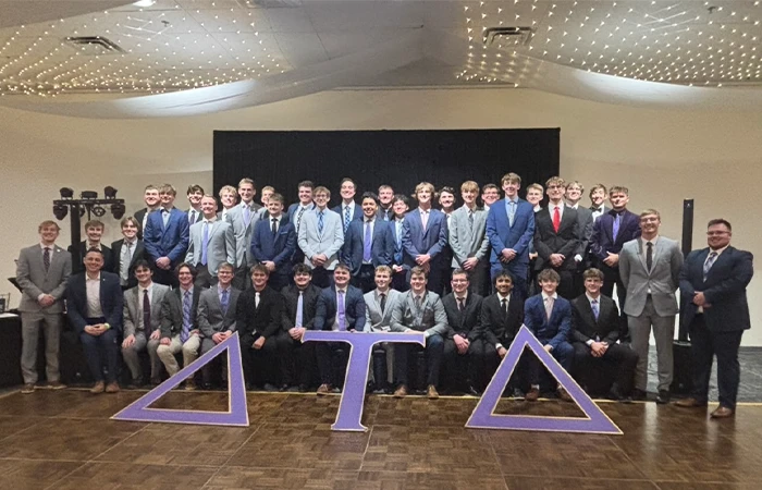 members of delta tau delta pose for a formal photo