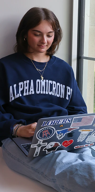 a Sorority member sits with her laptop