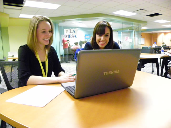 学生 working together on a laptop in the 太阳城娱乐官网 写作中心